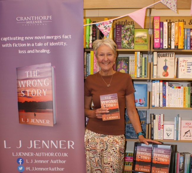 L. J. Jenner holding paperback copy of The Wrong Story